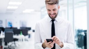 A man in white shirt holding a phone